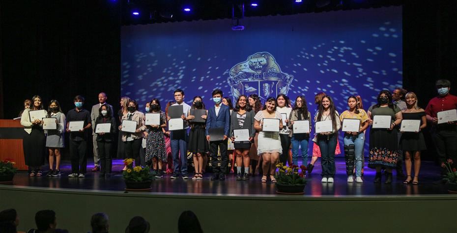 Students on Stage Holding Certificates